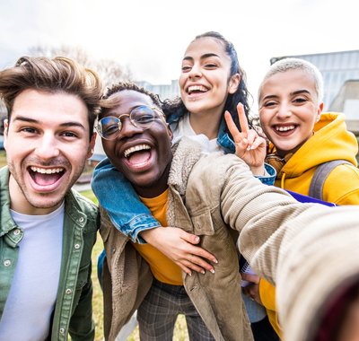 Lesmateriaal over vrijheid en gelijkheid. Middelbare scholieren van allerlei afkomsten lachen met elkaar voor de school.