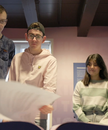 MBO scholieren bladeren door grondwet in Hof van Nederland.