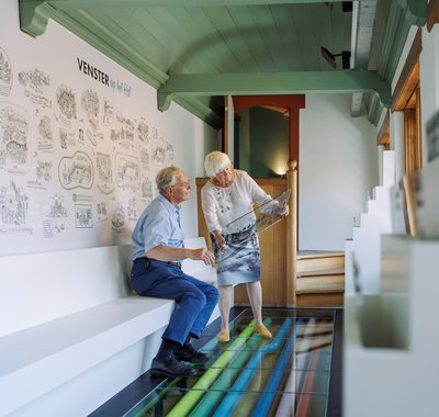 Twee oudere mensen bekijken een plaat in Hof van Nederland.