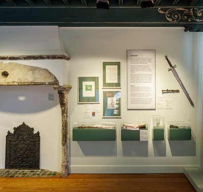 Een zaal in het museum met onder andere een zwaard en een haard.