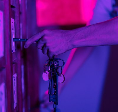 Een hand met sleutel probeert de code te kraken in de escaperoom.