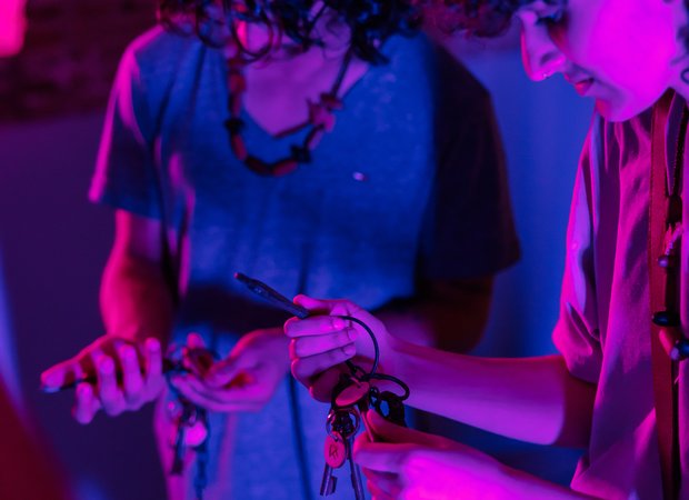 Jonge man en vrouw zoeken naar de juiste sleutel in een donkere escaperoom.