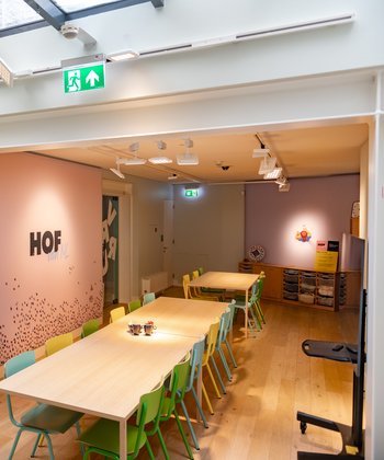 Een vergaderzaal met vrolijke uitstraling door de gekleurde muren en stoelen.